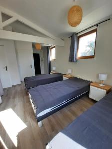 a bedroom with two beds and a window at Les Amarres belle maison 1,5km de la plage in Saint-Denis-dʼOléron