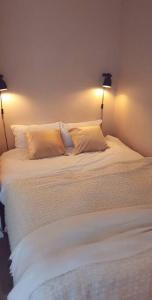 una camera con un letto bianco e 2 lampade di Appartement Cosy Paris centre a Parigi