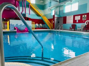 - une piscine avec toboggan dans un bâtiment dans l'établissement Ramada by Wyndham Belleville Harbourview Conference Center, à Belleville