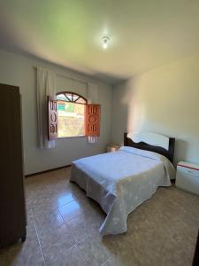 een slaapkamer met een bed en een raam bij Casa Raiz in Valença
