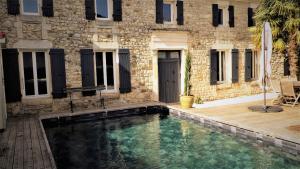 una piscina frente a un edificio en Le Logis du Breuil - Piscine privee, en Saujon