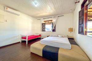 a bedroom with a bed and a bench in it at Casa com piscina e churrasq em Lauro de Freitas BA in Lauro de Freitas