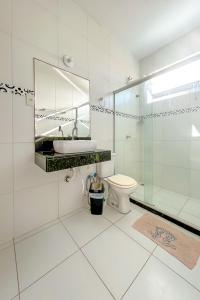 a white bathroom with a sink and a toilet at Casa com piscina e churrasq em Lauro de Freitas BA in Lauro de Freitas