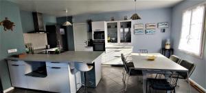 a kitchen with a counter and a table with chairs at Villa Ohana proche centre-ville in Le Château-dʼOléron
