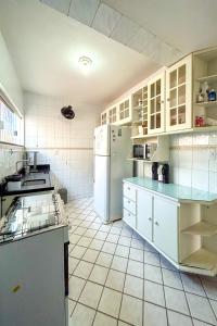 a kitchen with white cabinets and a white refrigerator at Casa com piscina e churrasq em Lauro de Freitas BA in Lauro de Freitas
