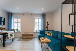 - un salon avec un canapé bleu et une table dans l'établissement Apartament Ratuszowy - Przytulny, w ścisłym Centrum - Space Apart, à Jelenia Góra