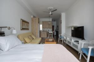 1 dormitorio con cama, sofá y TV en Estudio con vistas al mar en Las Canteras, en Las Palmas de Gran Canaria