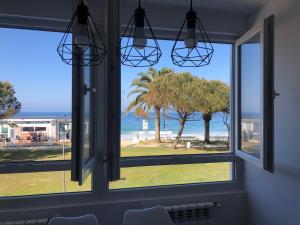 a room with a window looking out at the beach at Apartamento Comillas Beach in Comillas