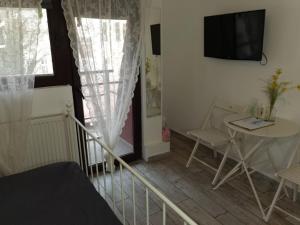 a small room with a table and a television on the wall at Stay In Tmisoara in Timişoara