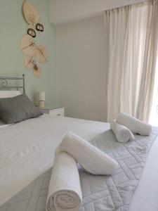 um quarto com uma cama branca e toalhas em M.V Apartment em Atenas