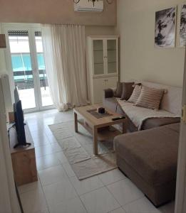 uma sala de estar com um sofá e uma mesa de centro em M.V Apartment em Atenas