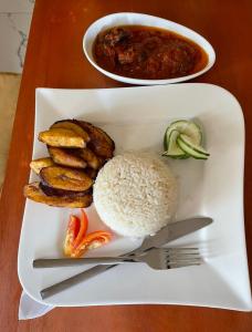 a plate of food with rice and vegetables on a table at Oceanfront Wavecrest Hotel in Lekki