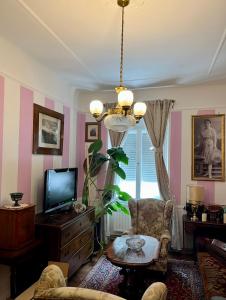 een woonkamer met een tv en een kroonluchter bij City-Apartment S in Graz