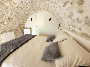 ein Schlafzimmer mit einem Bett mit einer Steinmauer in der Unterkunft Chaleureuse bergerie rénovée. in Tourrette-Levens