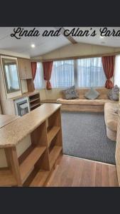 a living room with a table and a couch at Linda/Alan's Happy Holiday Home in Rhyl