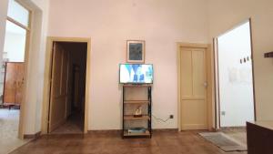 a living room with a television and a doorway at Sicilia Nica - appartamento privato a Cinisi (PA) in Cinisi