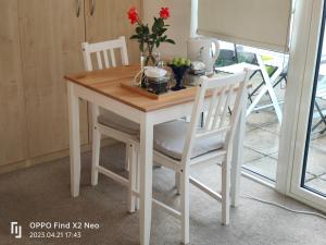 a kitchen table with two chairs and a table with flowers on it at Hendon Central, Private room ensuite in London