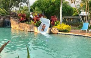 a resort pool with a teddy bear on a raft in the water at Step to beach New Quiet Kiahuna Plantation Remodeled 2 bedroom condo with AC in Koloa