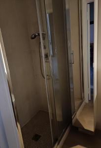 y baño con ducha y puerta de cristal. en Ànita holiday house, en Montemerano