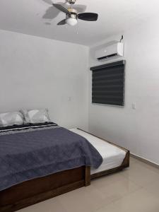 a bedroom with a bed and a ceiling fan at Departamento 103 in Mazatlán
