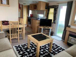 a living room with a couch and a table and a kitchen at 6 Berth Caravan on Sealands Site. Double Glazing in Ingoldmells