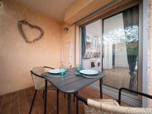 a table and chairs in a room with a kitchen at Appartement tout équipé terrasse parking privatif in Six-Fours-les-Plages