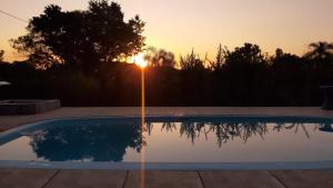 une piscine avec vue sur le coucher du soleil en arrière-plan dans l'établissement Chácara meu doce, à Socorro