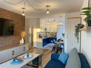 a living room and kitchen with a blue couch at Apartament Błękitne Spa in Ustrzyki Dolne