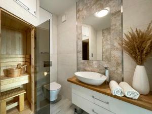 a bathroom with a sink and a mirror at Apartament Błękitne Spa in Ustrzyki Dolne