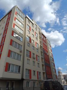 a tall building with red and white windows at Apartment COMFORT on Ruska street in Chernivtsi