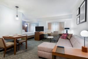 a hotel room with a couch and a living room at Residence Inn by Marriott Tampa at USF/Medical Center in Tampa