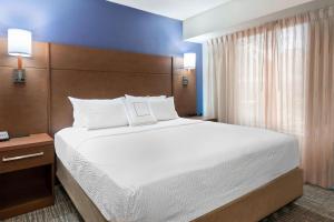 a bedroom with a large bed with white sheets and pillows at Residence Inn by Marriott Tampa at USF/Medical Center in Tampa