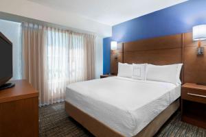 Residence Inn by Marriott Tampa at USF/Medical Center في تامبا: غرفه فندقيه سرير وتلفزيون