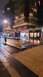 a city street at night with a yellow sign on the street at Spacious 2 bedroom flat in Baker street in London