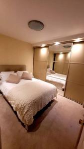 a bedroom with a large bed and a large mirror at Spacious 2 bedroom flat in Baker street in London