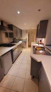 a large kitchen with white counter tops and appliances at Spacious 2 bedroom flat in Baker street in London