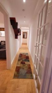 a hallway with a door and a rug on the floor at Spacious 2 bedroom flat in Baker street in London