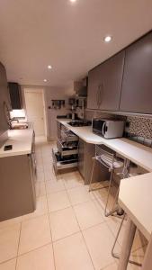 a kitchen with white cabinets and a counter top at Spacious 2 bedroom flat in Baker street in London