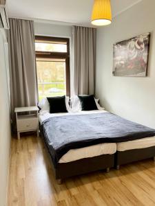 1 dormitorio con 1 cama grande en una habitación con ventana en APARTAMENT AST en Władysławowo