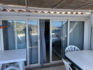 a screened in porch with a table and chairs at Appartamento La Terrazza al Gallo di Gallura in Santa Teresa Gallura