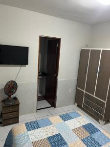 ein Wohnzimmer mit einem TV und einer Tür zu einem Schrank in der Unterkunft Apartamento acolhedor Maracanaú -Premium in Maracanaú