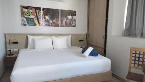 a bedroom with a white bed with a white candle on it at Hotelito del Mar Playa del Carmen in Playa del Carmen