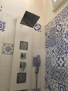 a bathroom with blue and white tiles on the wall at Hotel Il Vascello in Marina Serra