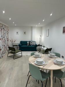 sala de estar con mesa, sillas y sofá en Gorgeous New 2 Bed Flat - 2 August House en Londres