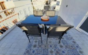 a blue table and two chairs on a balcony at Casa Rosa in Olhão