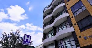 een hoog gebouw met een hotelbord ervoor bij Hotel Expo Hotel Ferial in Bogota