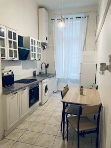 Appartement authentique coeur de ville sete في سيت: مطبخ مع طاولة وطاولة وكراسي