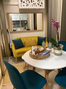 a living room with a table and a yellow couch at Appartement de standing Le Velvet Bay climatisé en bord de mer in Antibes