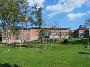 a field with trees and a building in the background at Japanese Auberge Plaza Ryokufu Natural Hot Spring - Vacation STAY 03265v in Shimo-orube