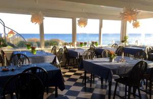 ein Restaurant mit blauen Tischen und Stühlen und Meerblick in der Unterkunft Badehotel Harmonien in Ærøskøbing